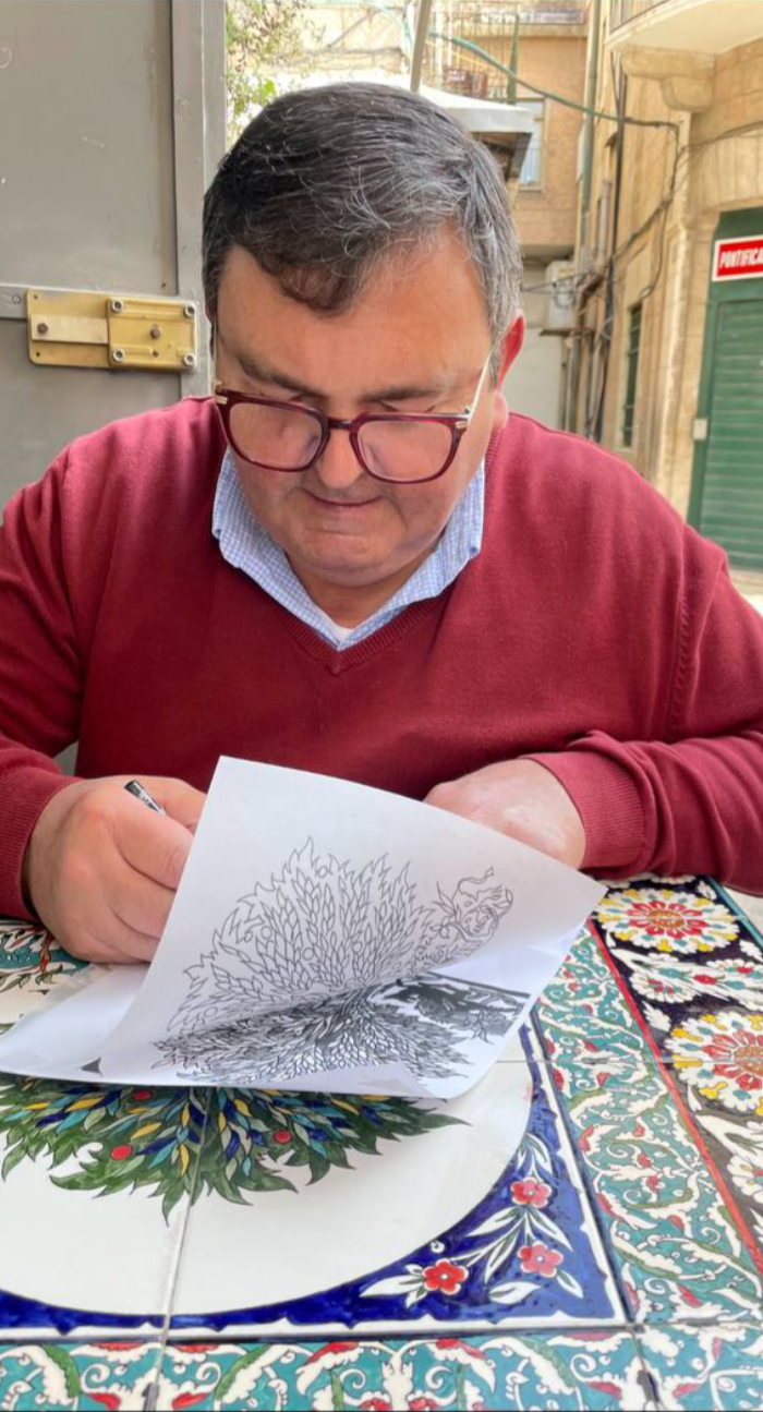 George Sandrouni drawing a detailed ceramic design on paper
