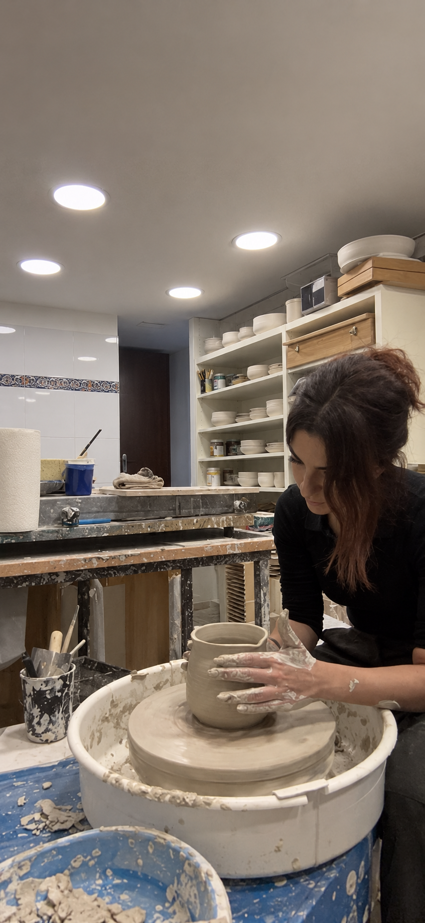 Karin Sandrouni shaping clay at a pottery wheel
